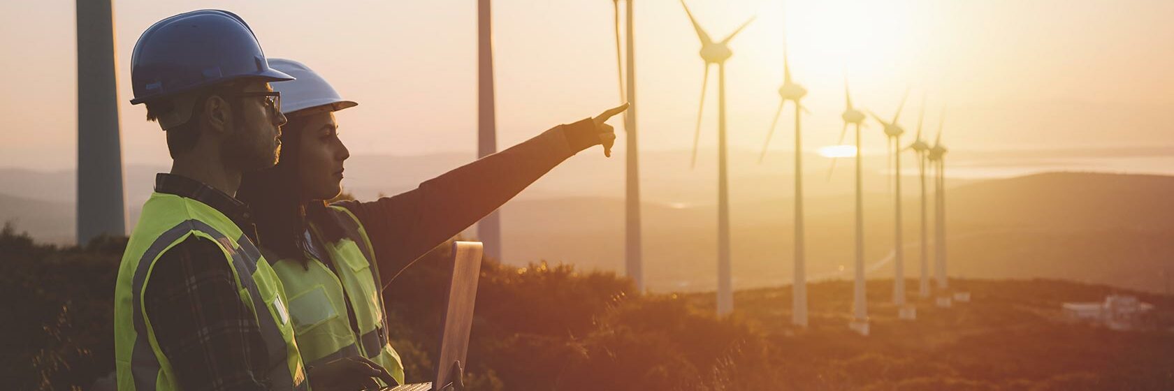 Expert's from Sweco discussing renewable energy with wind turbines in the background