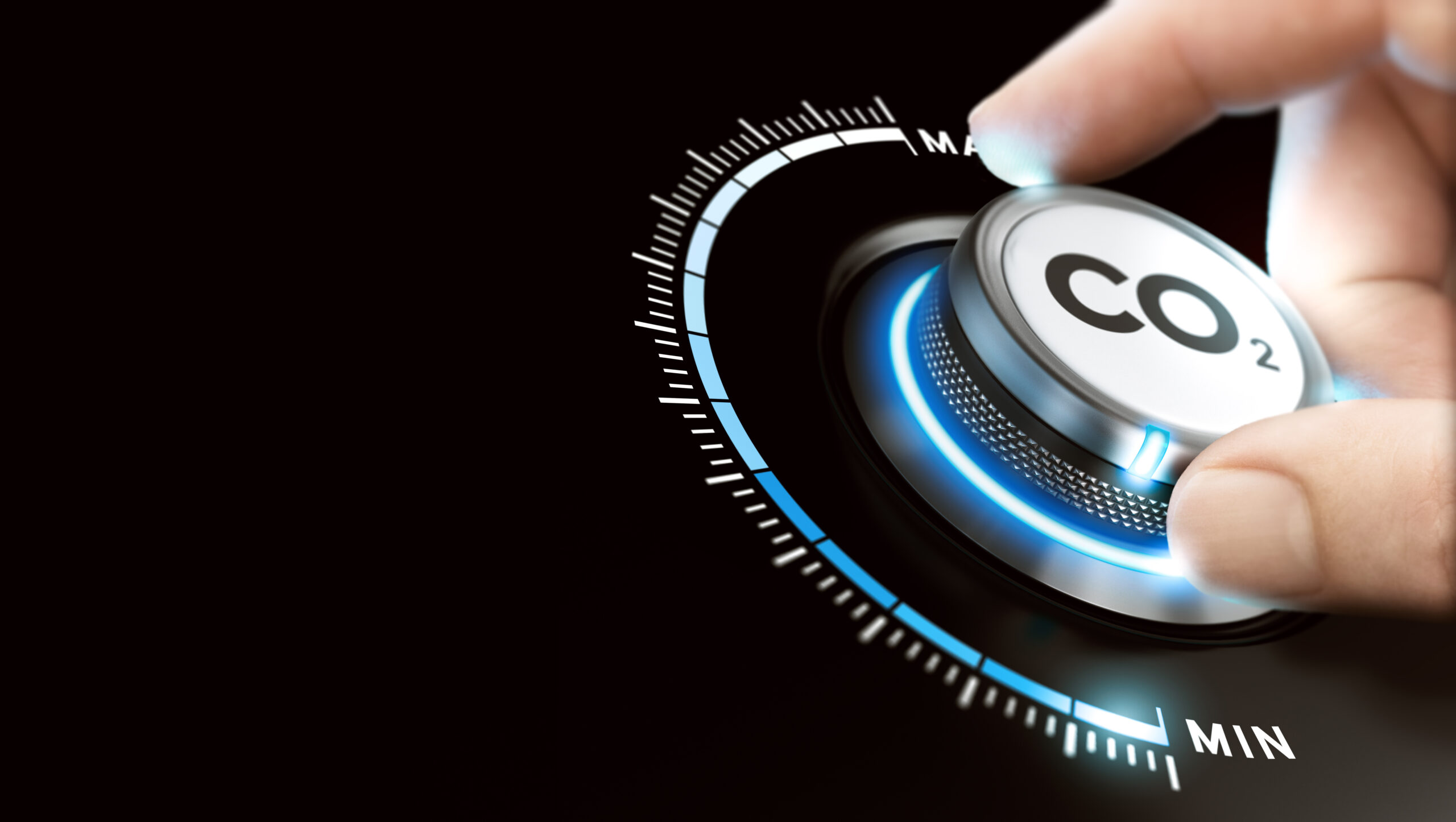 Hand turning a carbon dioxide knob button to reduce emissions