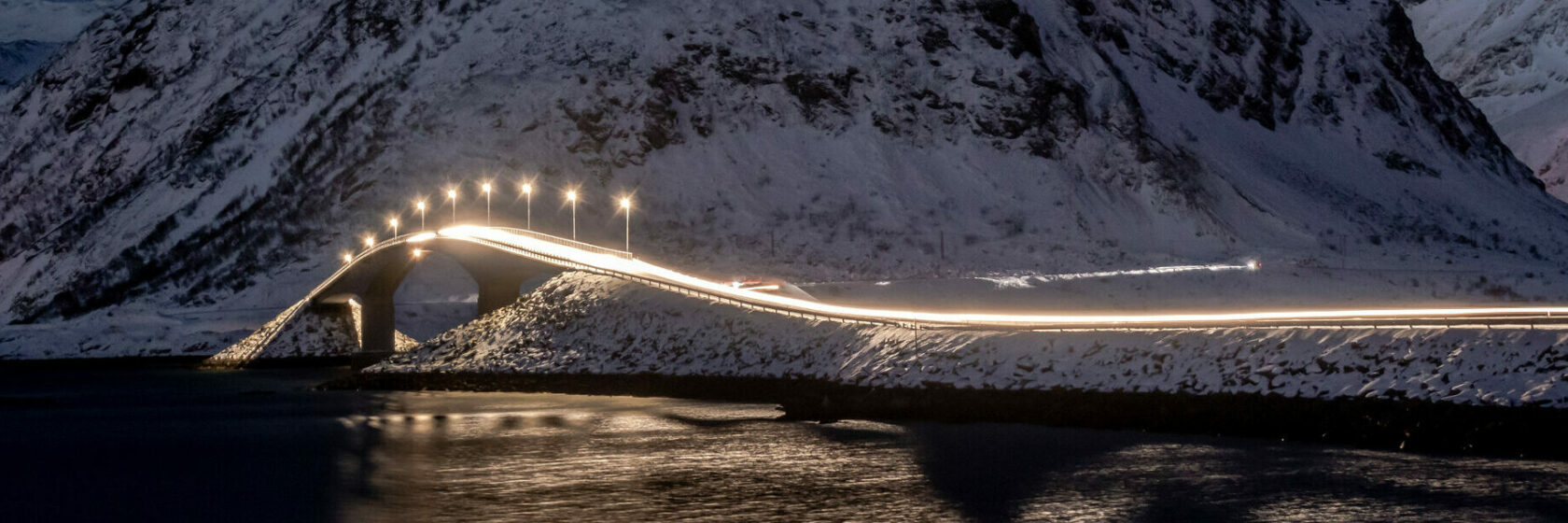 One of the Fredvang Bridges with the Volanstinden Mountain in winter and at night