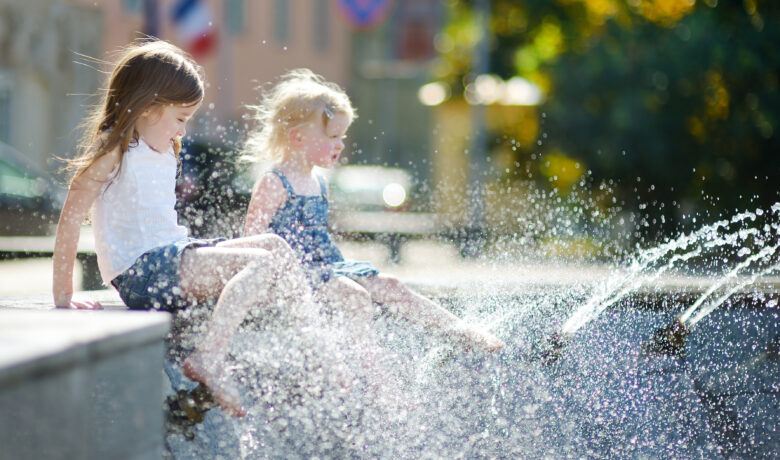 girls playing with a city fountain