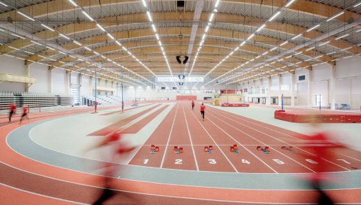 two people running in an indoor arena