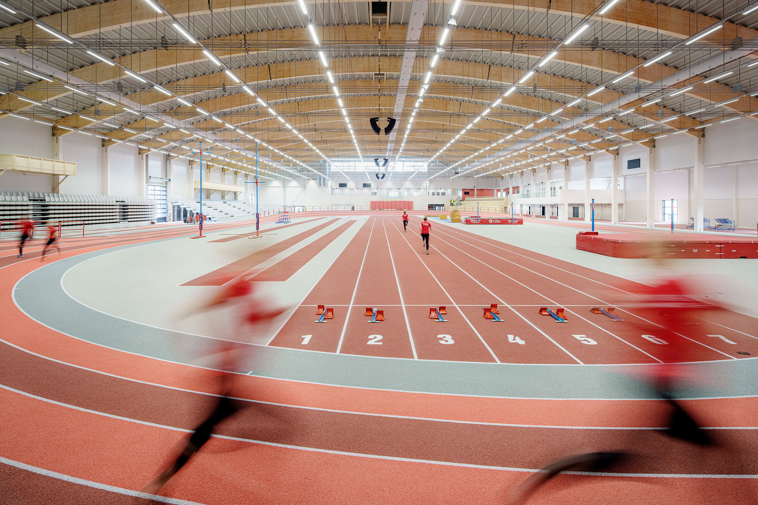 two people running in an indoor arena