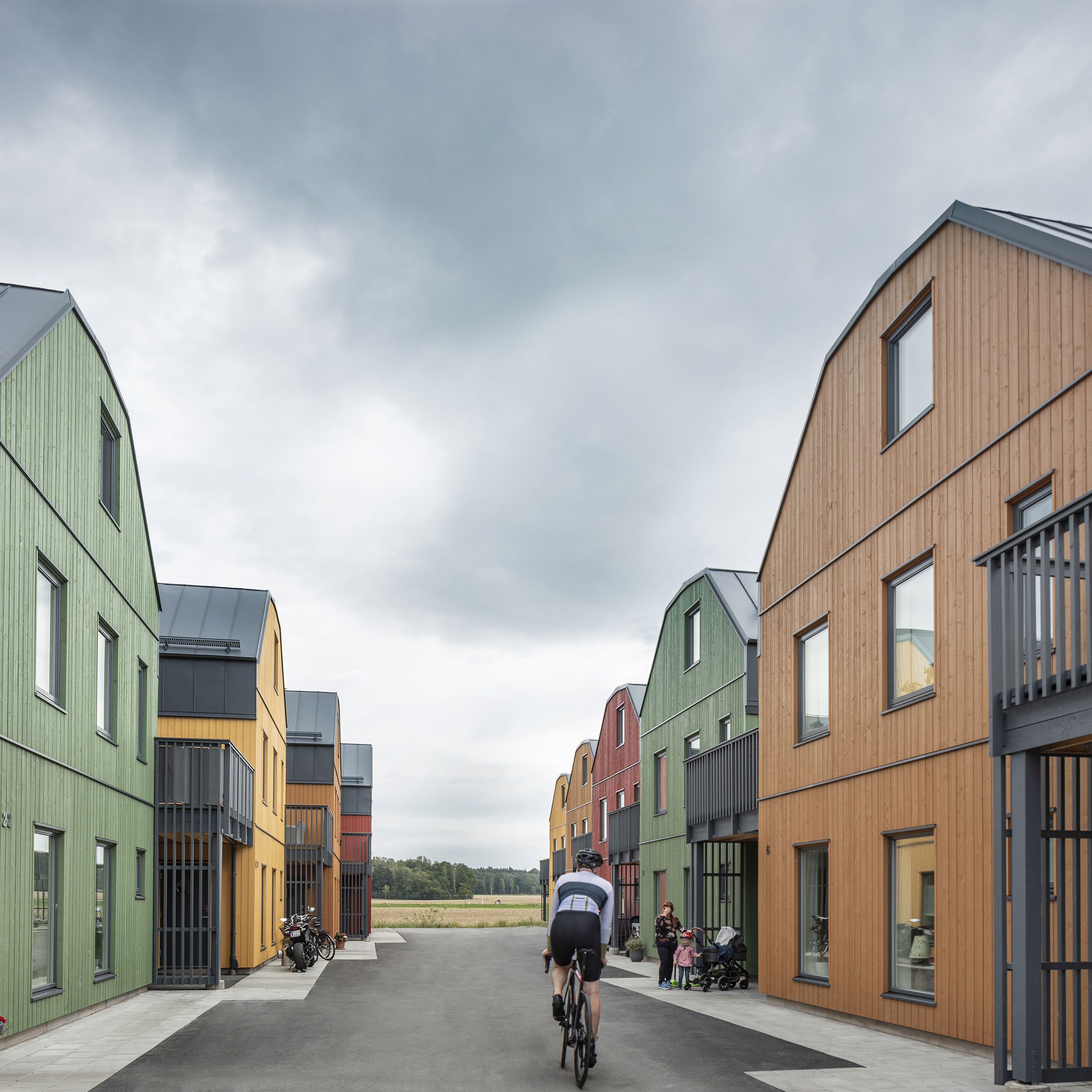 Housing area in different colours and a man on bike