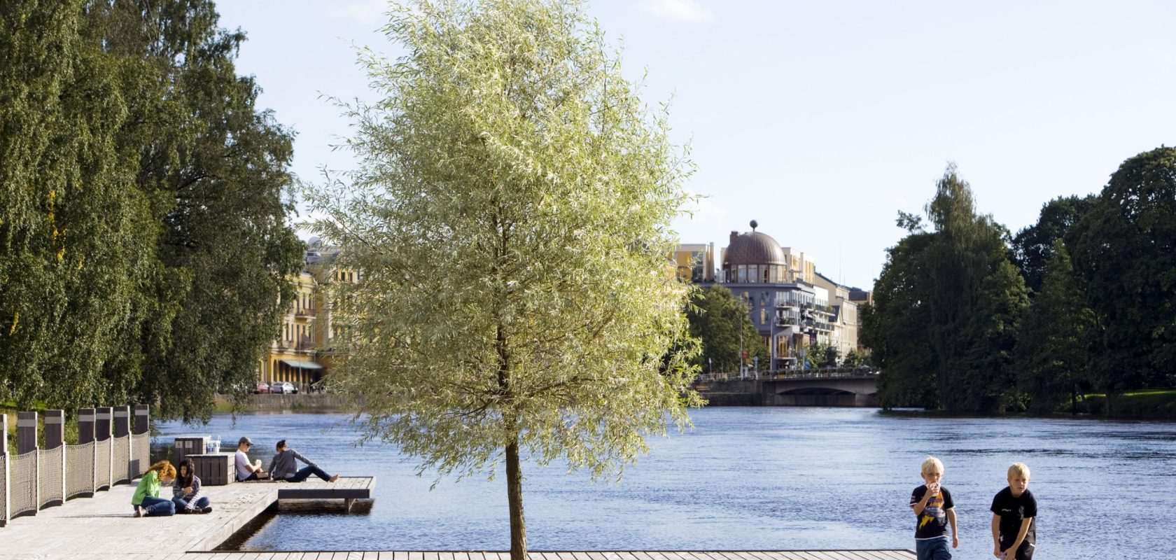 A park located on a sandy reef along the river running through a city