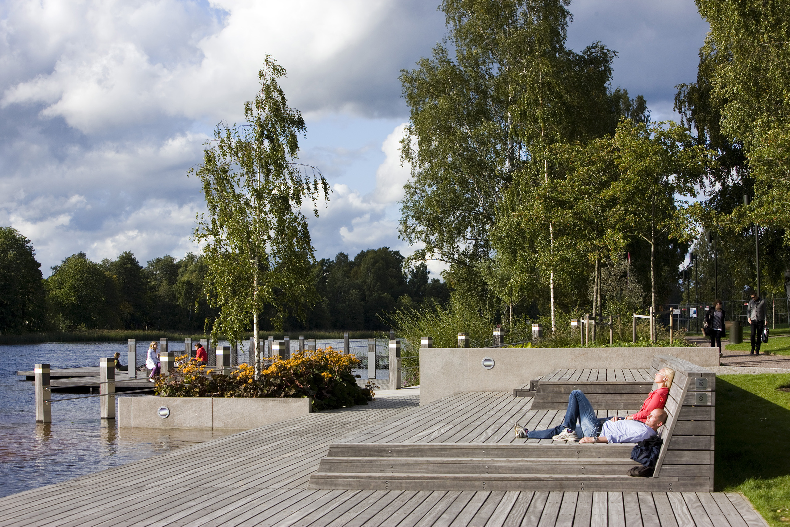 People chilling in a park by a river