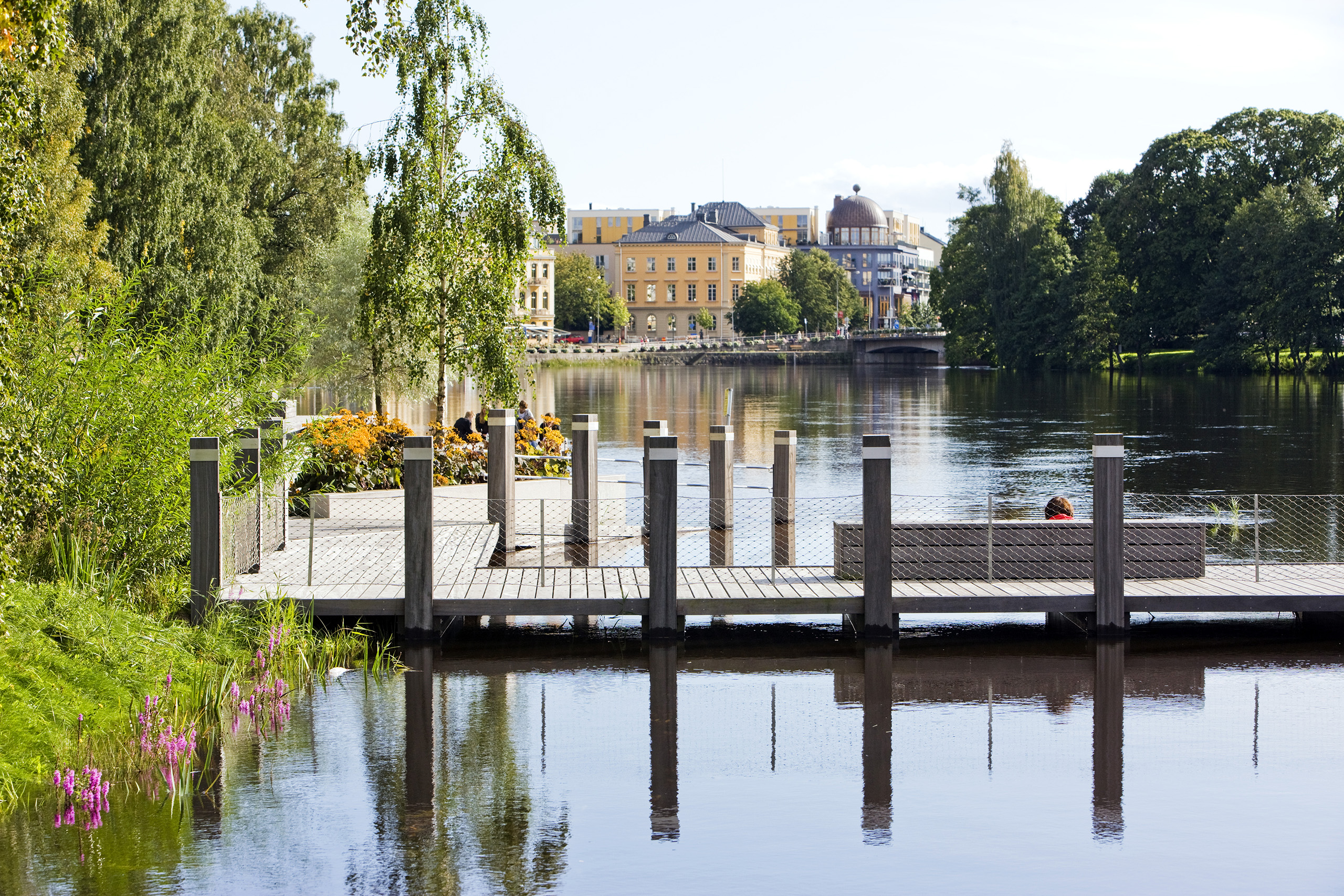 A park located on a sandy reef along the river running through a city