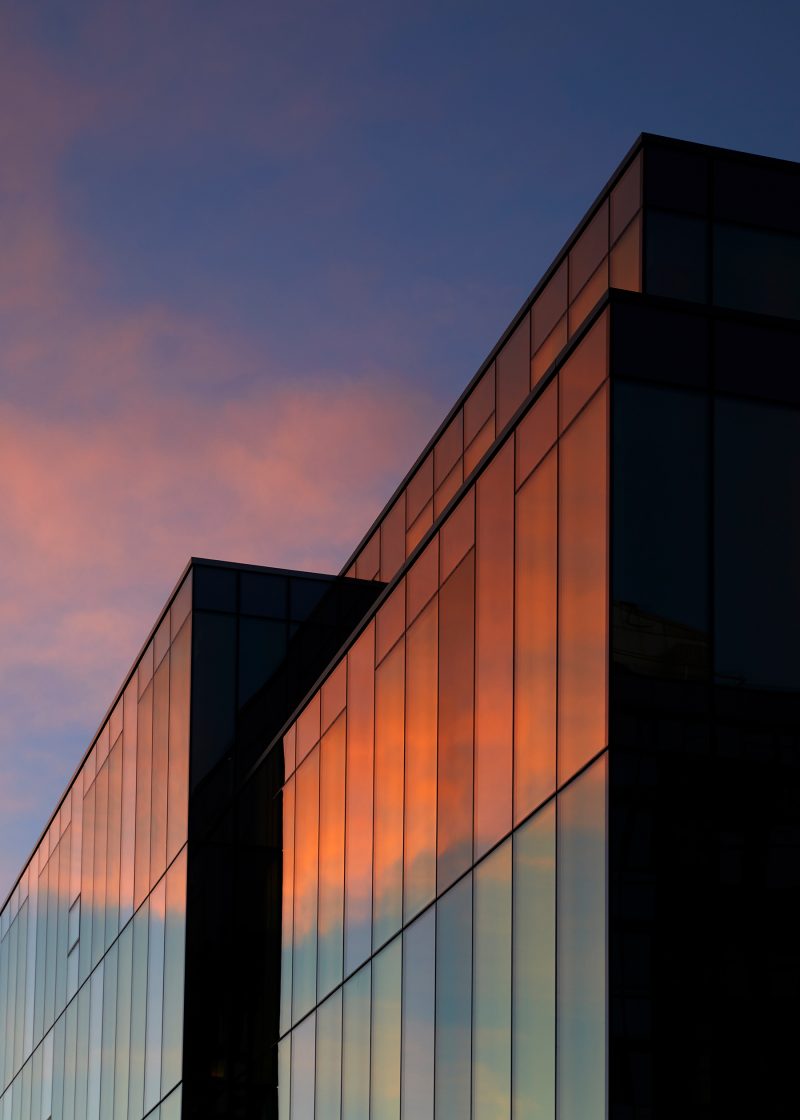 Glass facade of office building in the sun set.