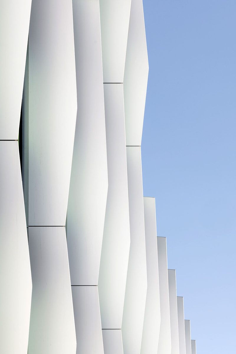 Close up showing the vertical white elements and a blue sky in the background.