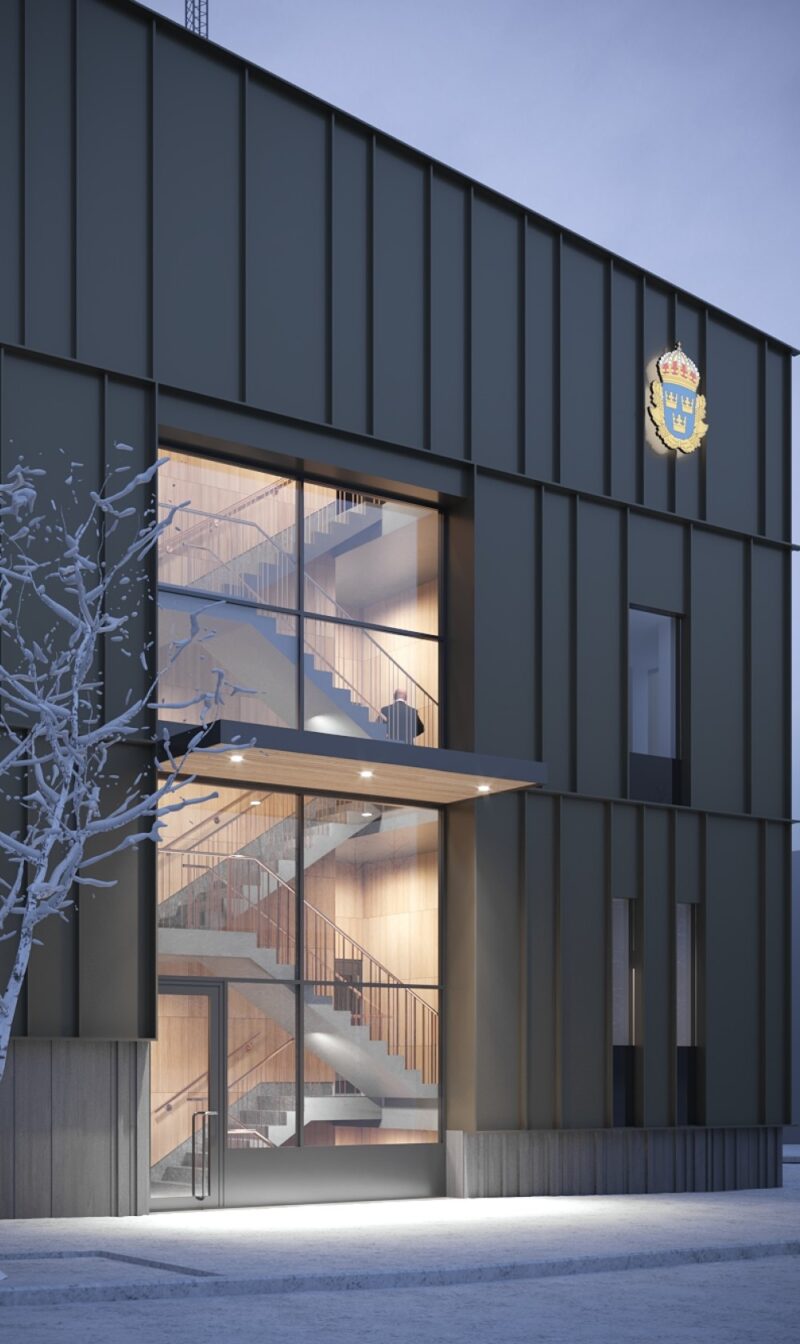 Visualization of the facade of a police station with a larger glass section in the middle, an entrance on the ground floor and stairs to the other floors can be seen through the glass.