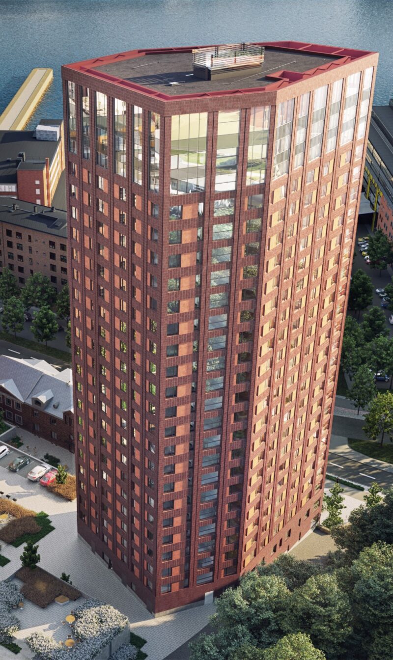 Close-up of the upper part of the 26-story high-rise residential building in brick. Large glazed areas on the top three floors.