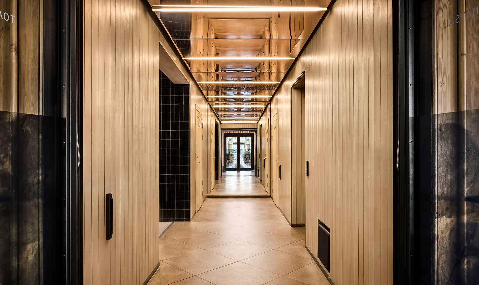 Nicely lit corridor with paneling in lighter wood.