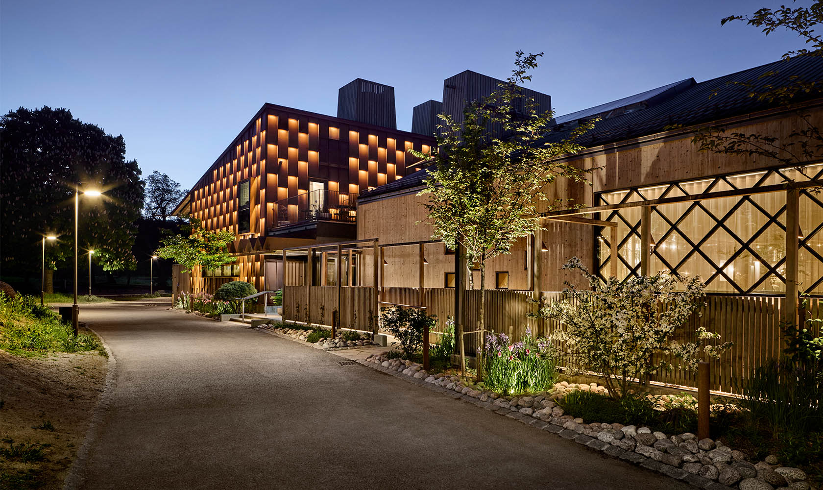 Evening photo of a walkway outside the restaurant building that is beautifully lit.