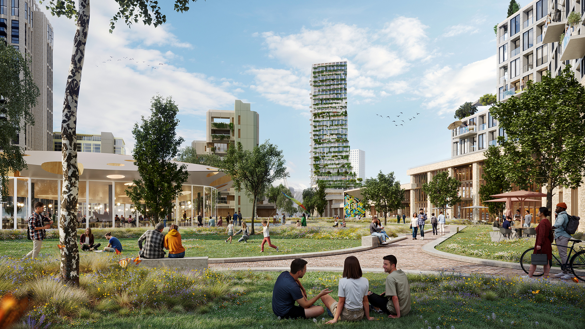 Walk and cycle path in park-like area with many people walking, sitting and cycling. Modern properties on the edge of the lane.