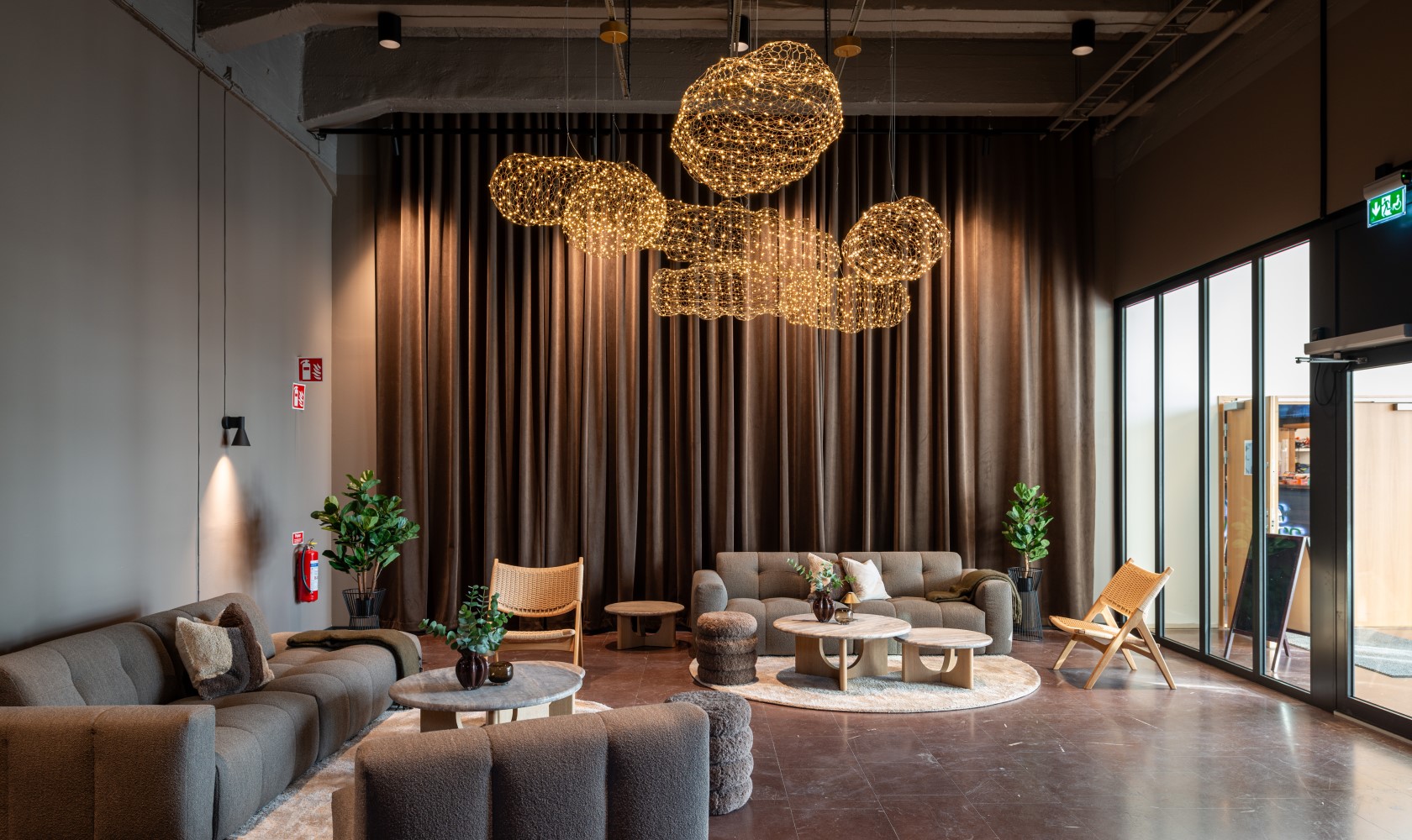 Open area with large sofas, stone flooring, and drapes in the background.