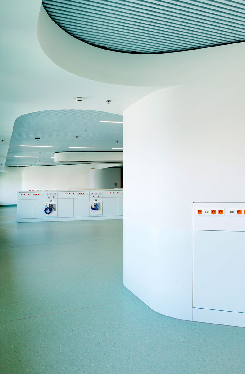 Interior image from an empty hospital building with bright colors and numerous outlets along the walls.