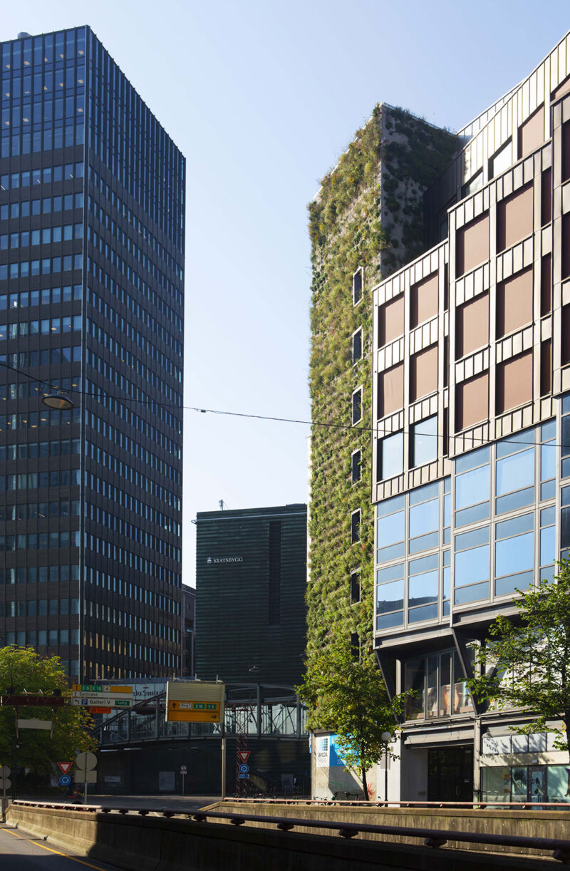 Facade image of a larger building in central Oslo where part of the wall is covered with vegetation.