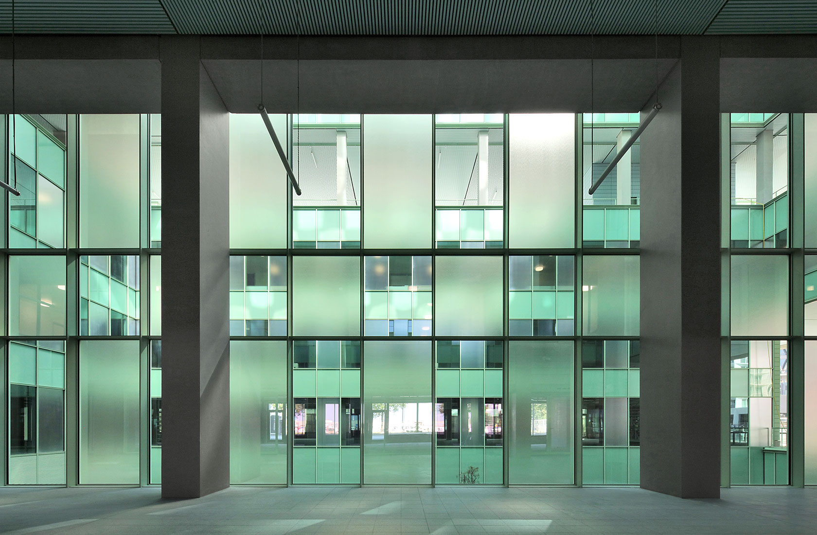 Close-up of a glass section facing the courtyard with panes of clear and frosted glass in green.