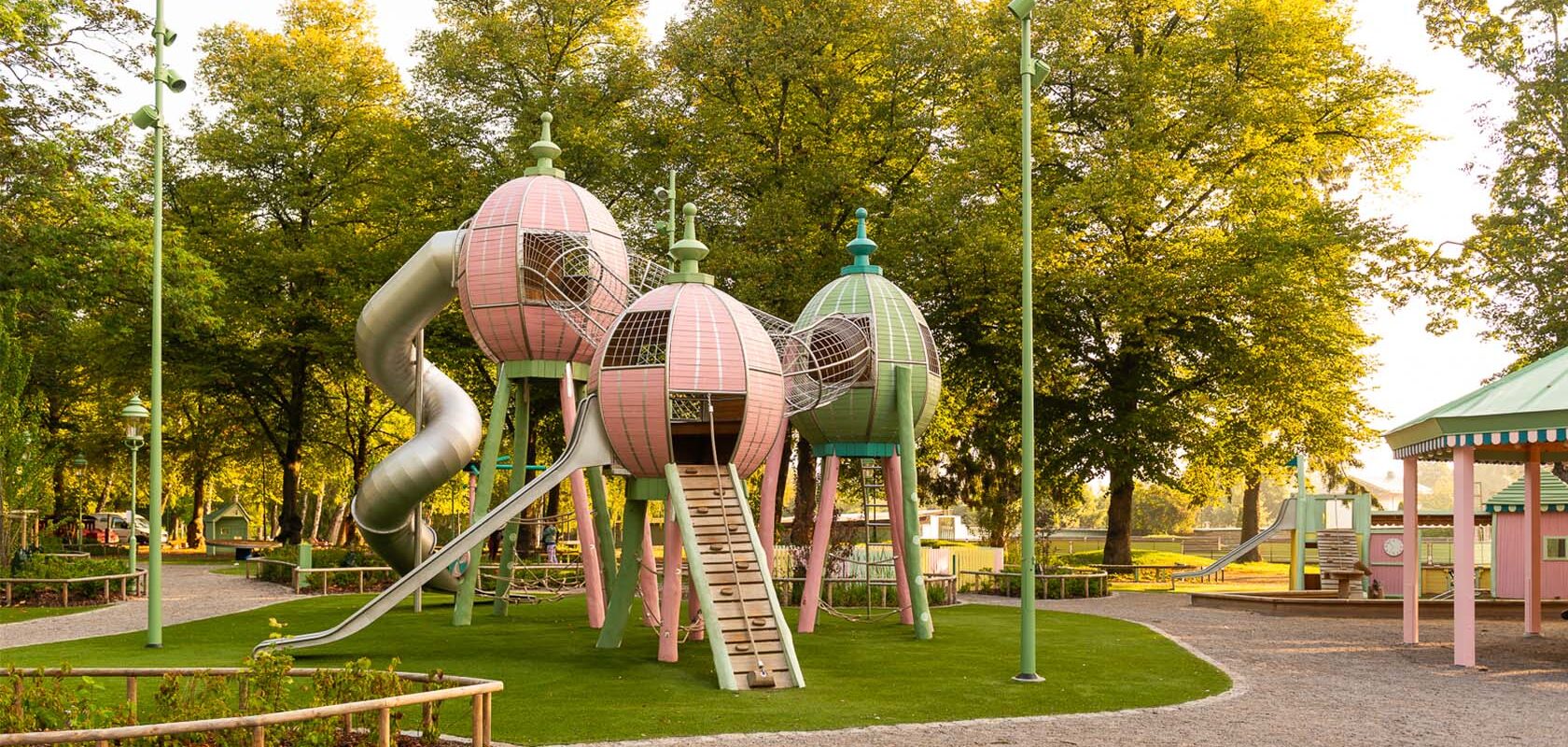 Tivoli-inspired playground in a green area with climbing frames and slides.