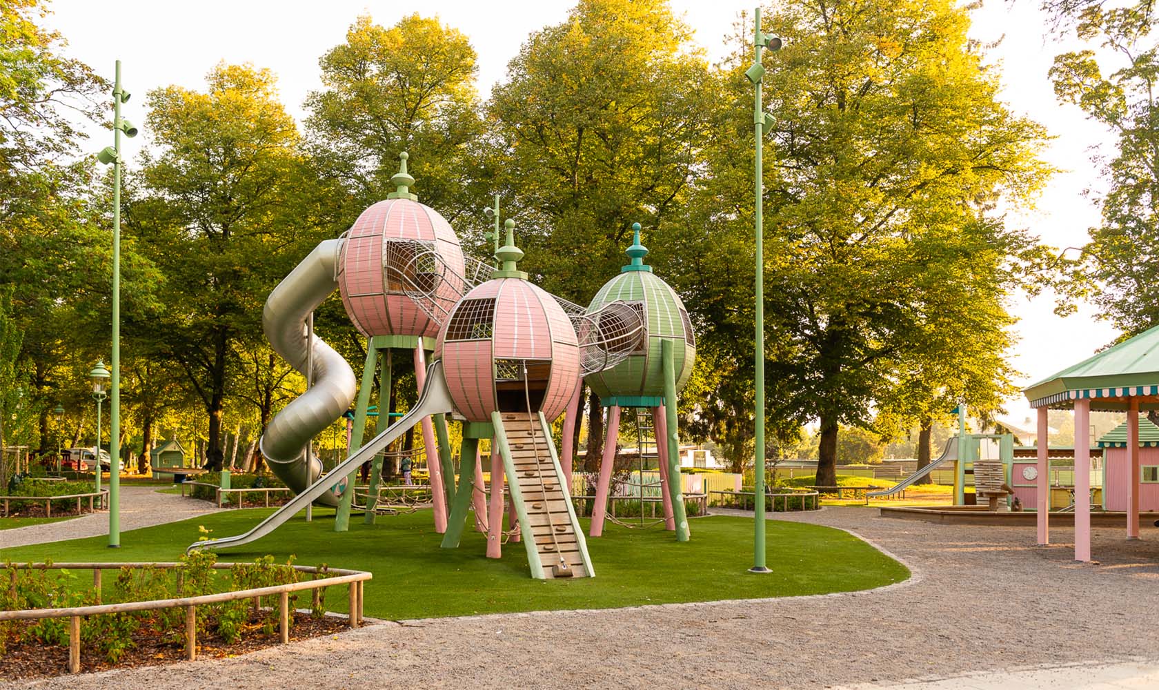 Tivoli-inspired playground in a green area with climbing frames and slides.