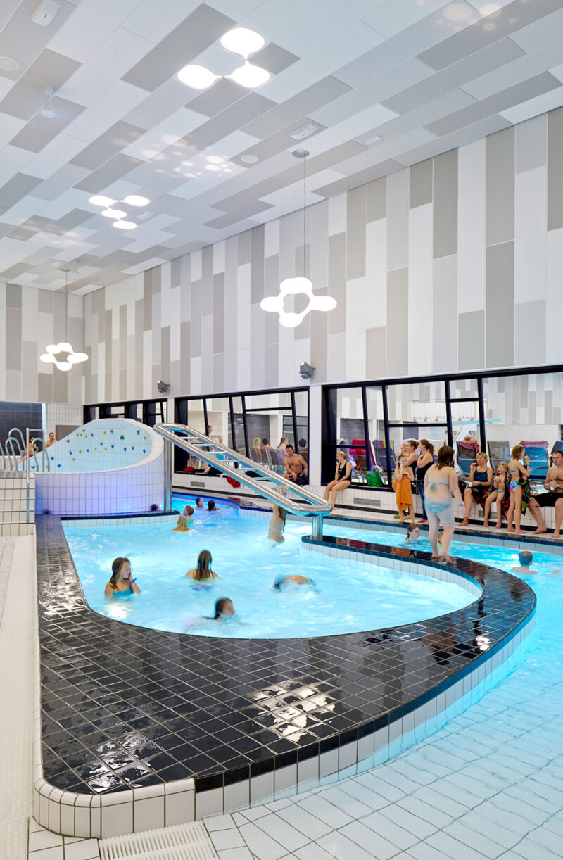 Adventure section in the swimming hall with many visitors.