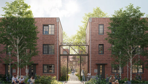 Brick residential buildings with people sitting outside near greenery and a sign reading "SMARIUSKADE".