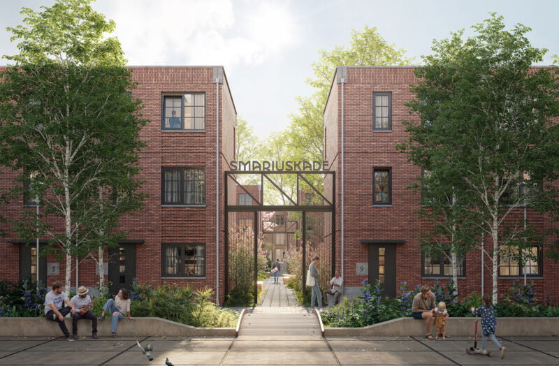 Brick residential buildings with people sitting outside near greenery and a sign reading "SMARIUSKADE".