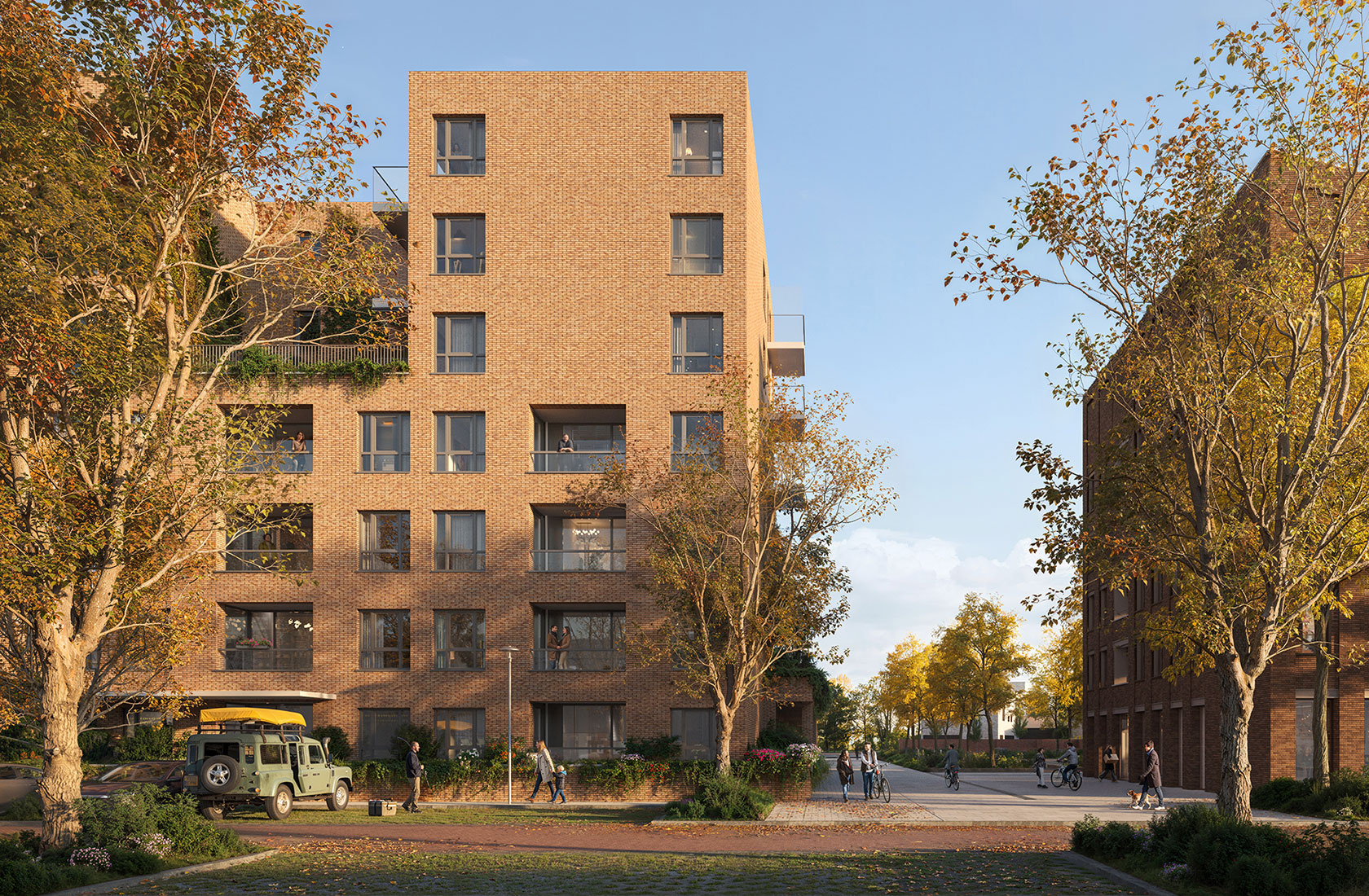 Modern apartment building with brick facade under clear sky, surrounded by trees and people walking.