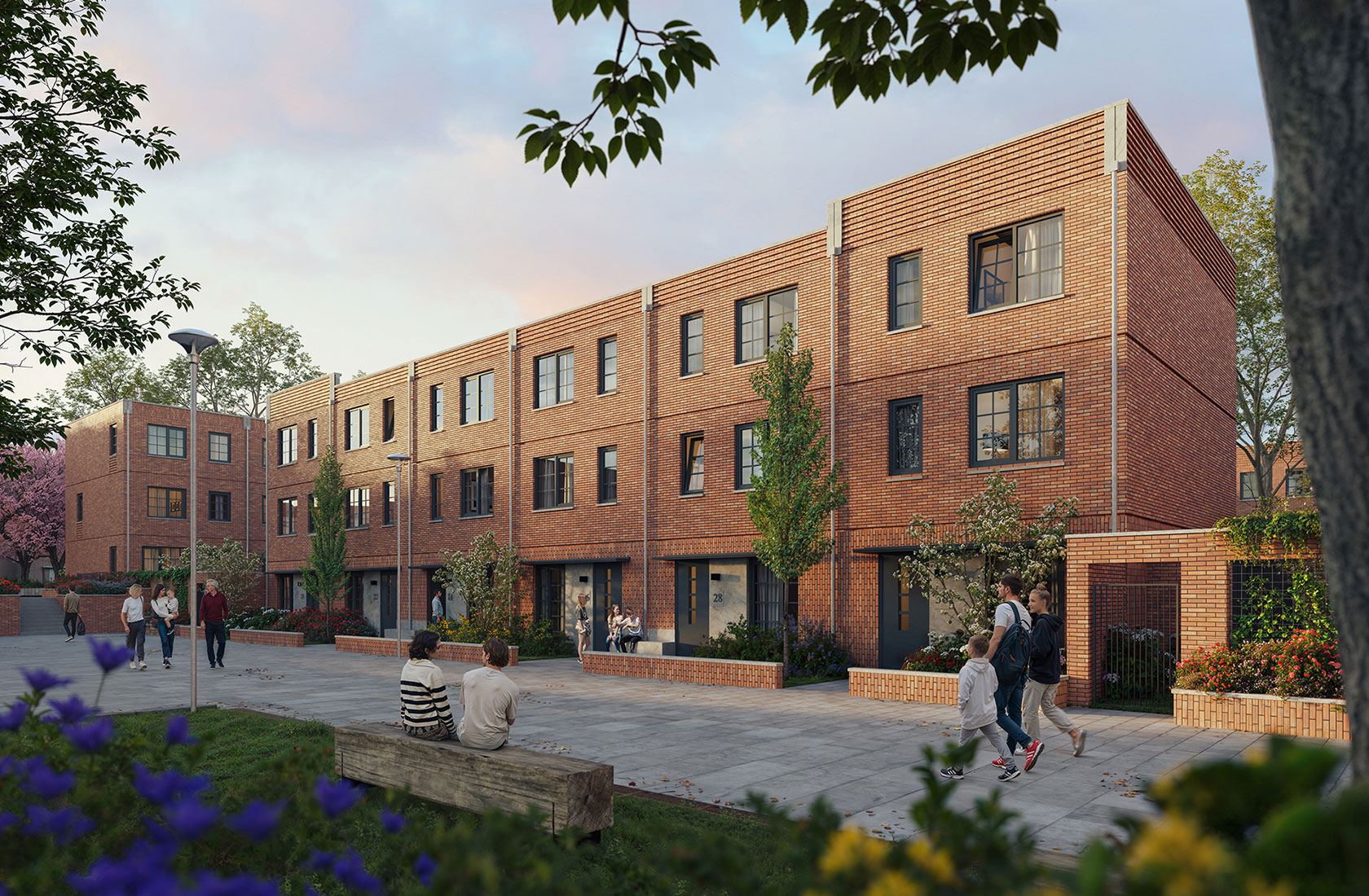 Modern townhouses with brick exteriors, people walking and sitting outside, greenery and flowers in foreground.