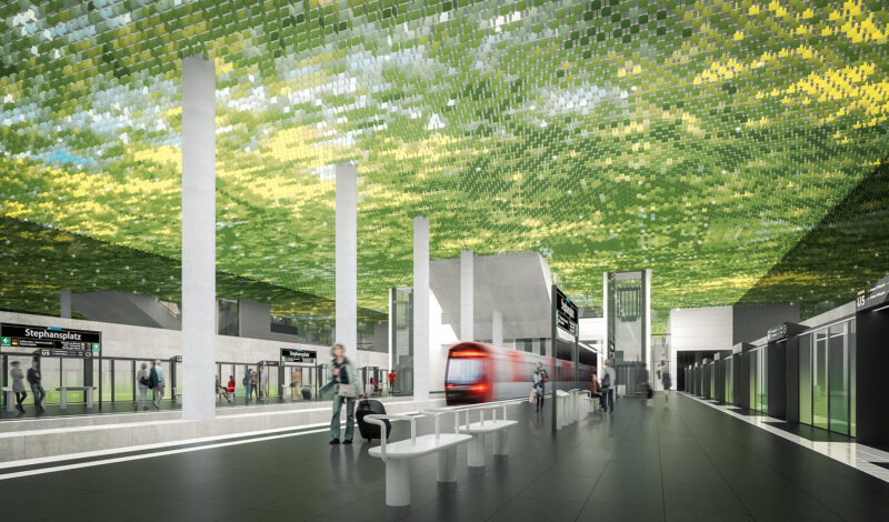Modern train station with green tiled ceiling, passengers boarding train, signs for Stephansplatz U5.