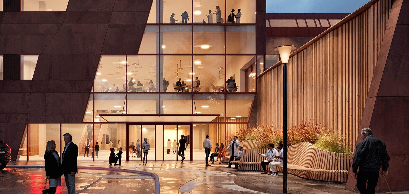 Modern hospital exterior at dusk with glass facade and people walking and sitting outside