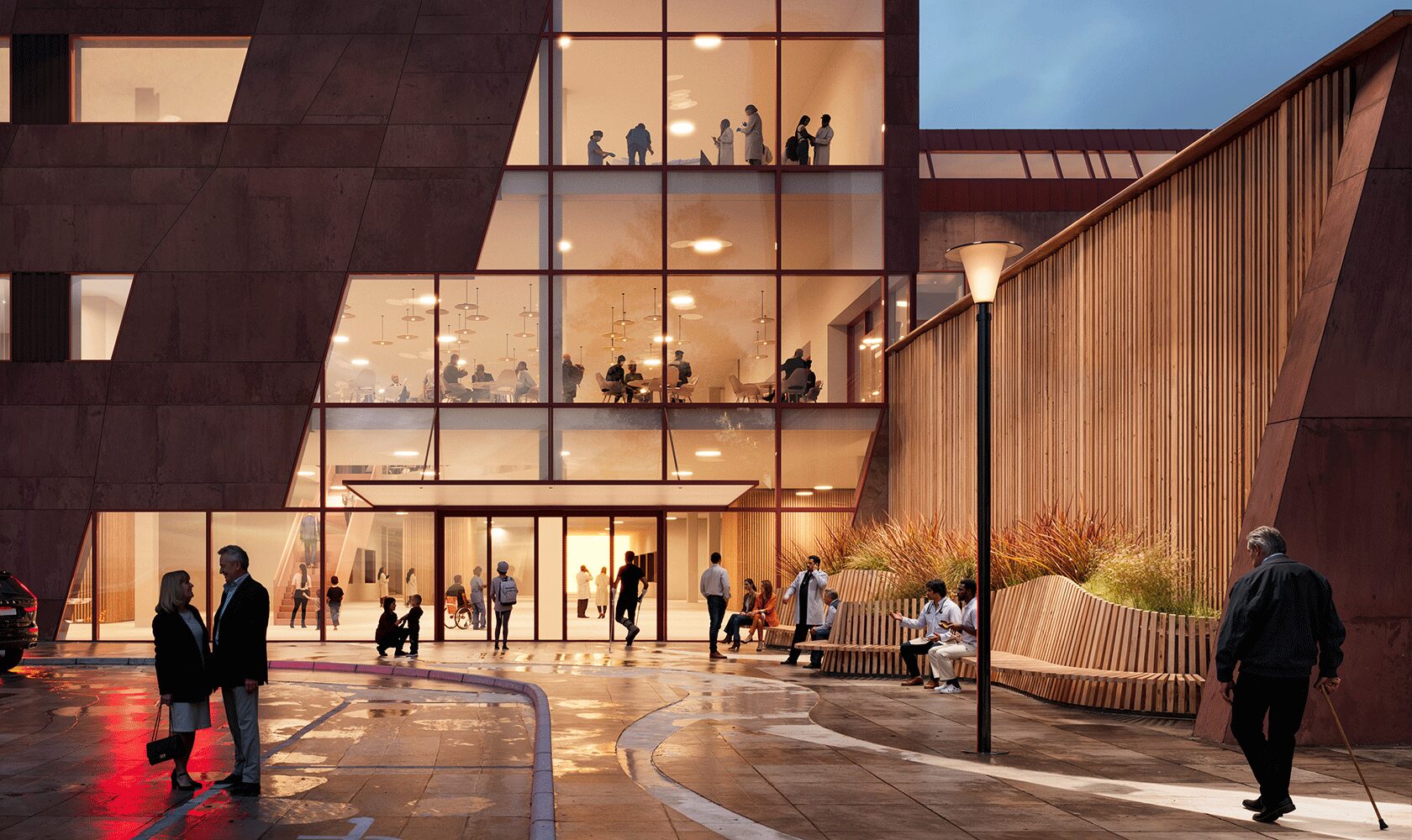 Modern hospital exterior at dusk with glass facade and people walking and sitting outside