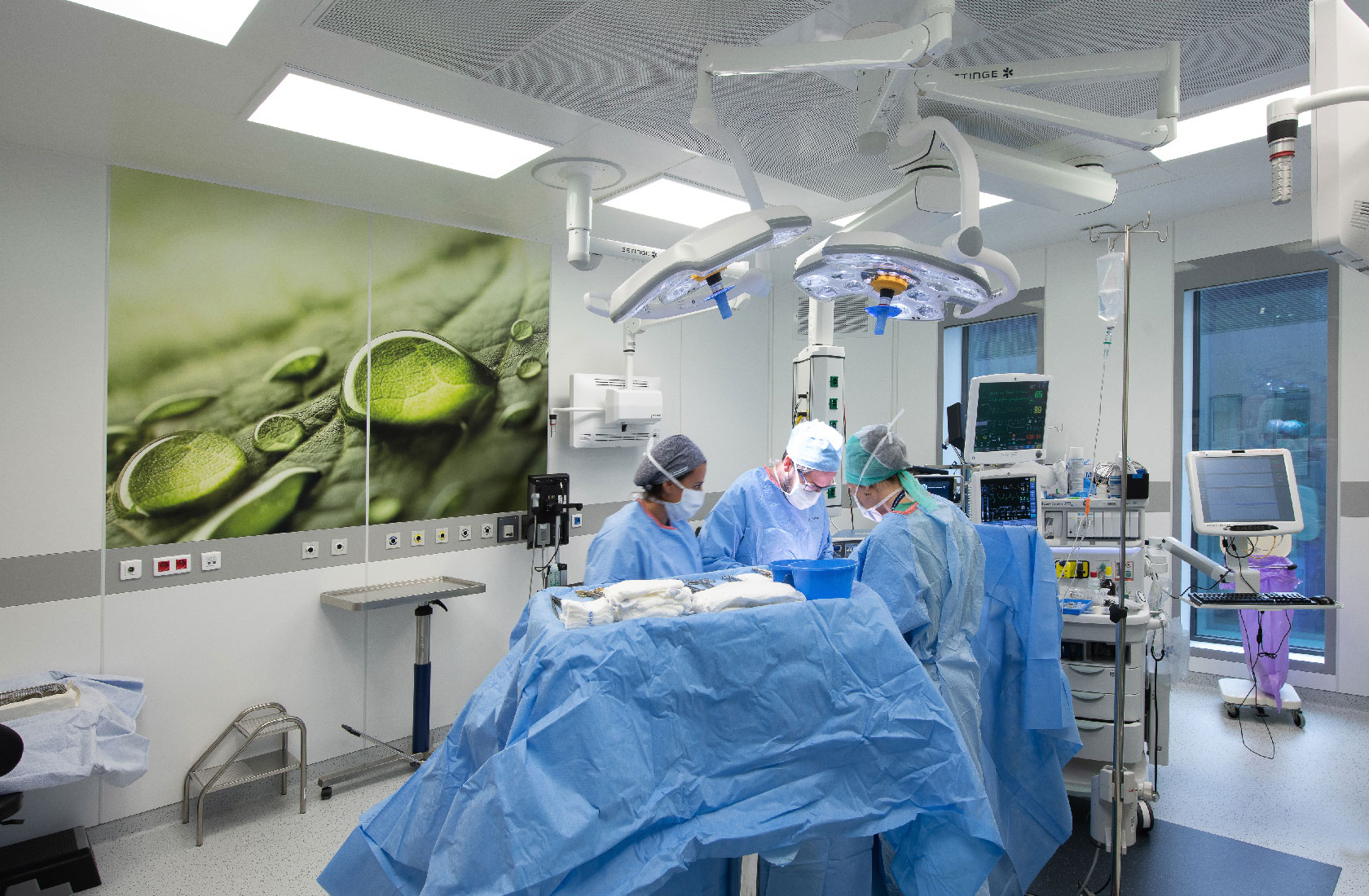 Surgeons performing operation in modern hospital operating room with medical equipment