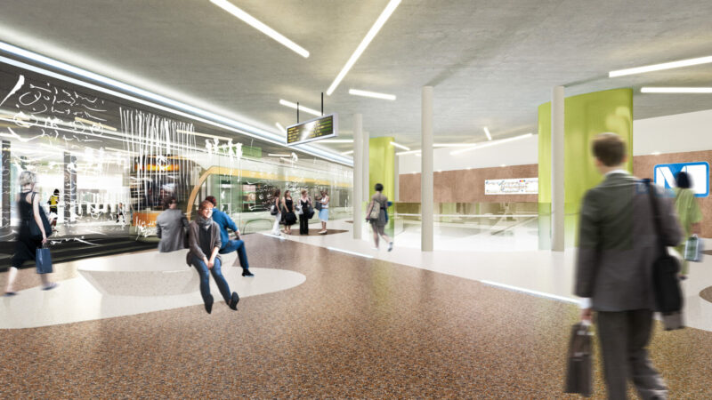 Modern metro station concourse with passengers, digital signboards, and green columns