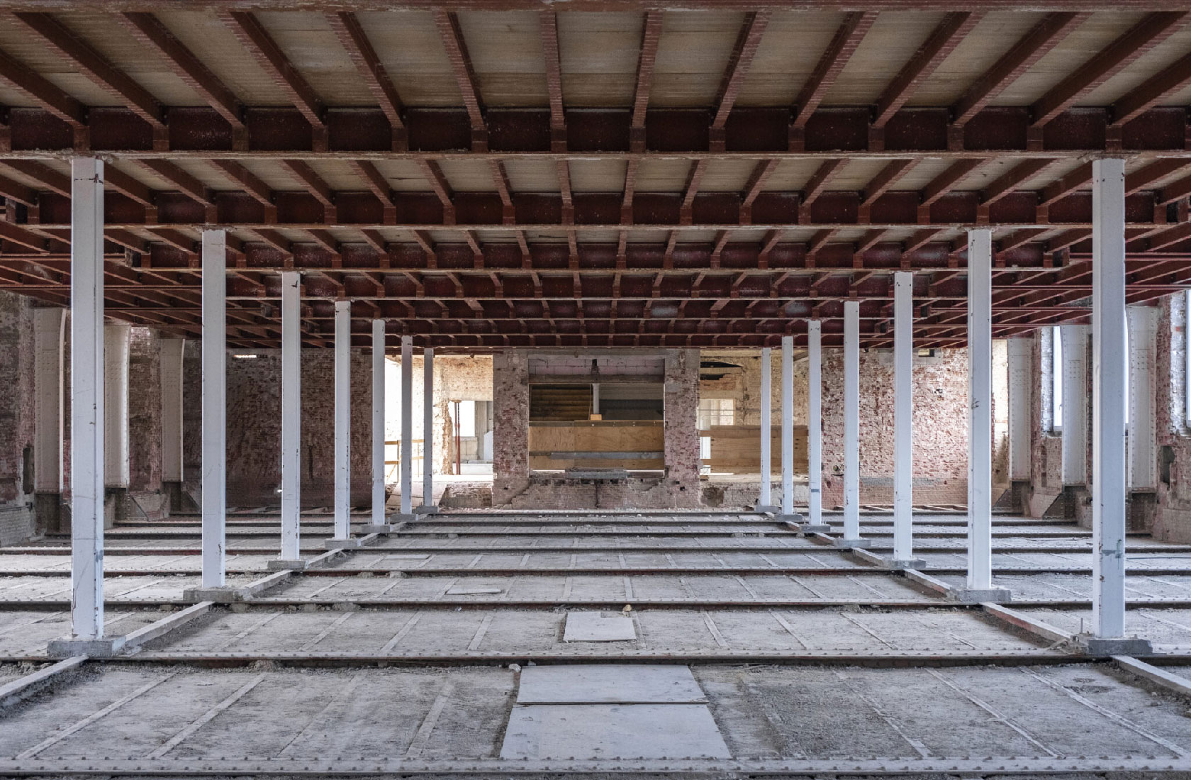 Empty warehouse interior with steel columns and exposed beams during renovation