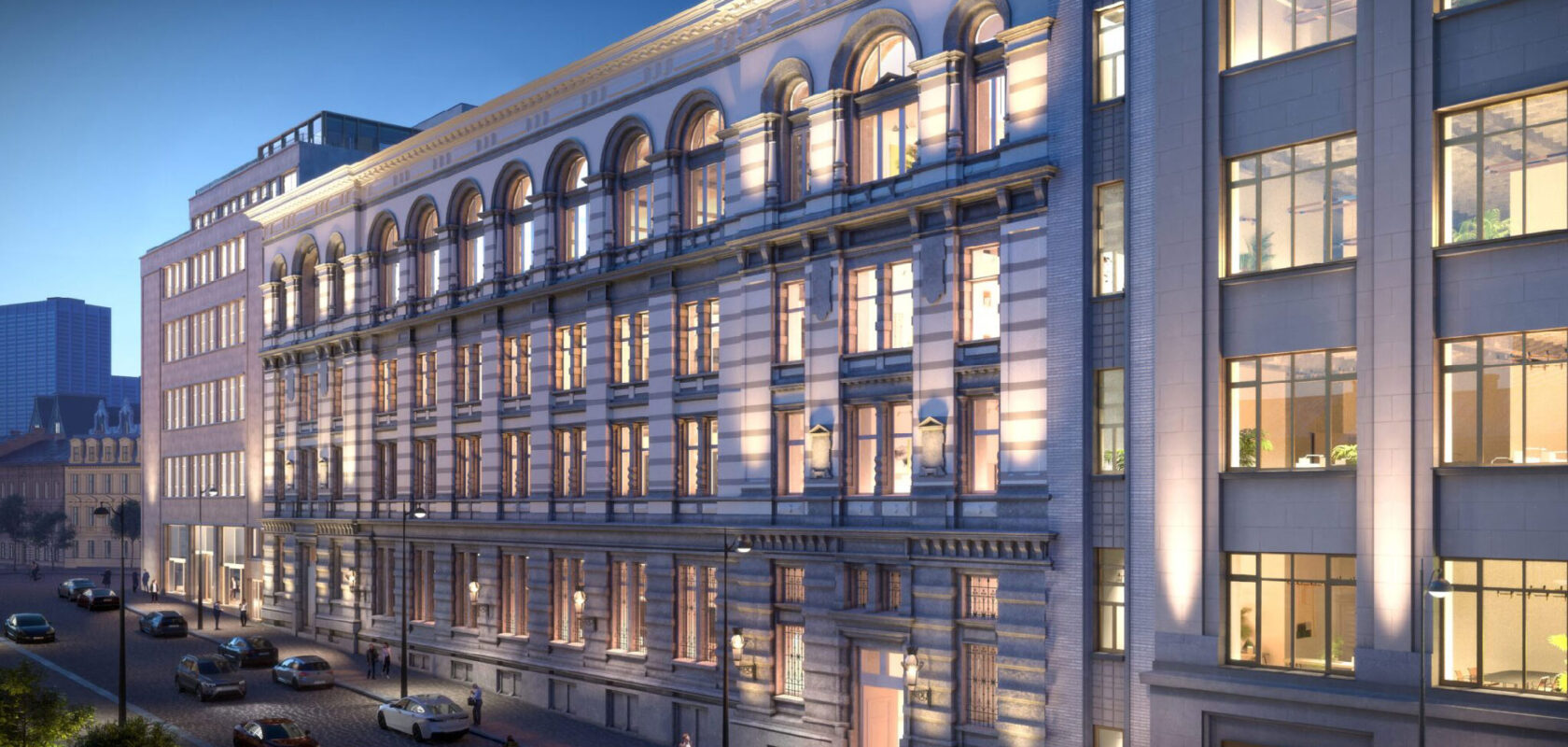Illuminated historic office building facade on city street at dusk with cars and pedestrians