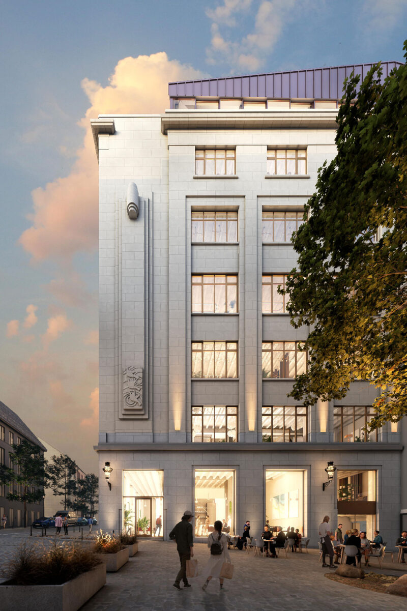 Modern white stone building with outdoor café seating at sunset in city square