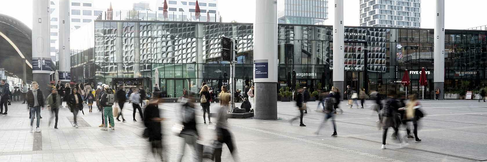 Mensen die wandelen op Hoog Catharijne Utrecht onder bollendak bij Utrecht Centraal Station